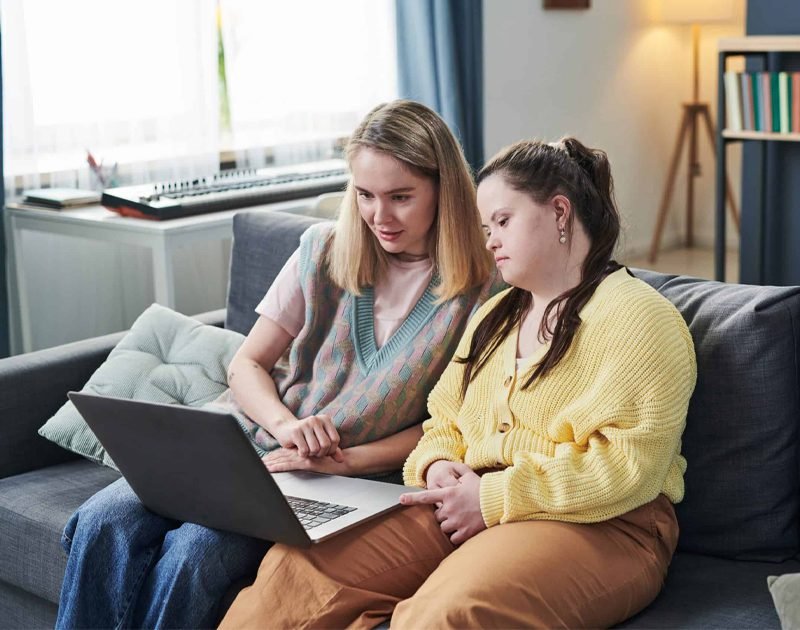Image depicting a support worker providing care to a client in a home setting, possibly at night