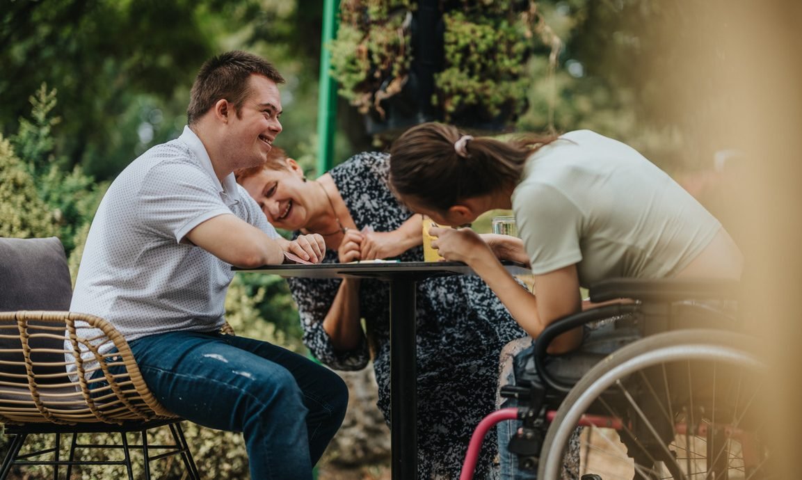 Image of a support worker and client enjoying a community event or park outing