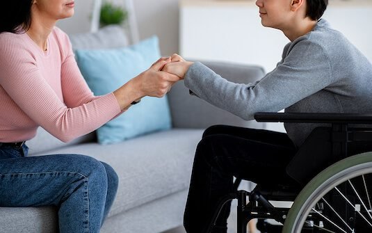 Image of a support worker engaging with a client while a family member is away, symbolizing respite