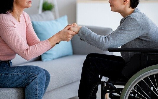 Image of a support worker engaging with a client while a family member is away, symbolizing respite